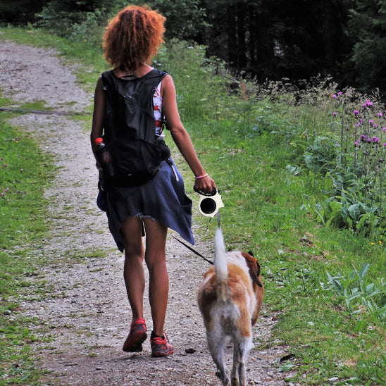 laisse pour chien en randonnée avec sa maitresse sur un sentier