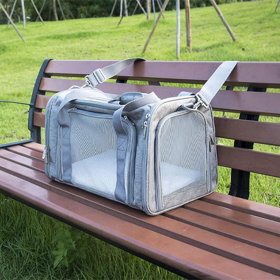sac de transport pour chien gris posé sur un banc